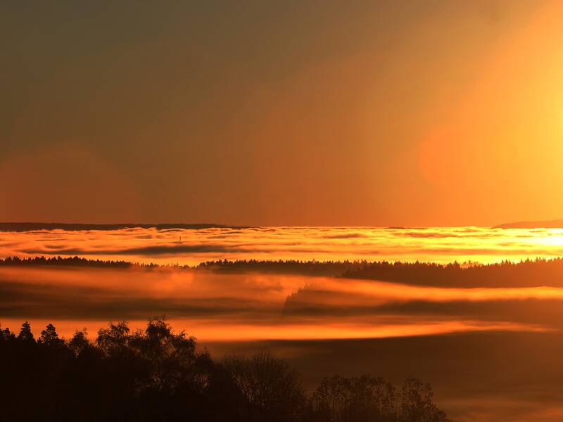 roter Sonnenaufgang mit Blick auf vernebelte Täler