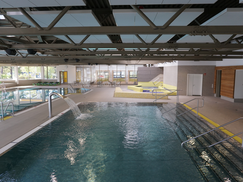 Blick von oben auf das Nichtschwimmerbecken mit einer Wasserdusche auf der linken Seite