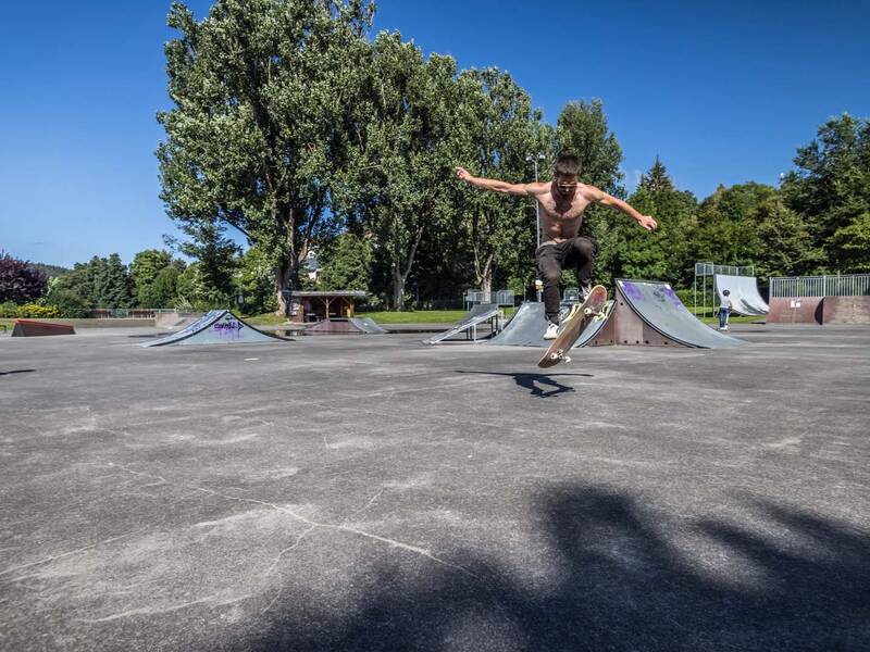 Junger Mann der einen Trick mit seinem Skateboard macht